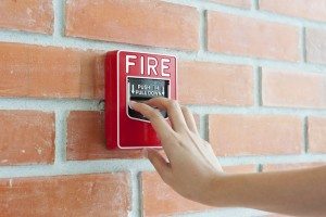 Hand pulling down fire alarm